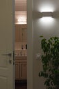 Wall LED lamps in the interior. Open white door to the bath Royalty Free Stock Photo