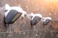 Wall lighting lanterns covered with snow with icicles from ice, and a video camera. Royalty Free Stock Photo