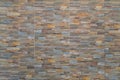 Wall lined with ceramic tiles, imitating a masonry made of stone of different types and colors