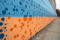 A wall with a lot of spots and a blue and orange background Royalty Free Stock Photo
