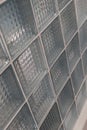 A wall made of clear glass blocks featuring geometric patterns reflects light and adds texture, enhancing a contemporary space Royalty Free Stock Photo