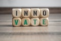 Wall made of cubes or dice with word INNOVATE on wooden background Royalty Free Stock Photo