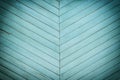 A wall made of diagonal slats. Bright green background with a texture of thin wooden boards.