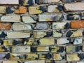 Wall made of old baked bricks, red brown white yellow black gray, close-up Royalty Free Stock Photo