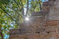 An old wall - the remains of a house - with the sun shining through the breach. Royalty Free Stock Photo