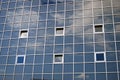 A wall made of square glass bricks. Blue sky with clouds reflection. Royalty Free Stock Photo