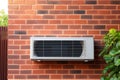 Wall mounted air conditioner is pictured on brick wall. This versatile image can be used to showcase cooling systems, en Royalty Free Stock Photo