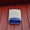 Wall mounted blue security alarm siren strobe light, perimeter warning emergency system unit, large detailed vertical closeup