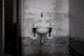 wall-mounted ceramic washbasin in old abandoned mansion