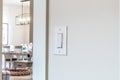 Wall mounted electrical rocker light switch with blurry dining room background Royalty Free Stock Photo