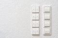 Wall-mounted light switches and roller shutter control switch on windows close-up Royalty Free Stock Photo