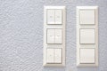 Wall-mounted light switches and roller shutter control switch on windows close-up Royalty Free Stock Photo