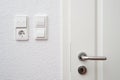 Wall-mounted light switches and roller shutter control switch on the windows next to the front door Royalty Free Stock Photo