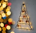 Wall-mounted minimalist Christmas tree decoration made of black wire forming a triangular shape. Royalty Free Stock Photo