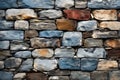 Wall of multicolored stones of different shapes embedded in cement mortar