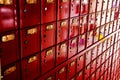Wall of multiple red mailboxes with metal doors, each featuring a gold number in  New Zealand Royalty Free Stock Photo