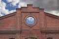 The wall of an old abandoned and ruined industrial brick building against a blue sky with clouds Royalty Free Stock Photo