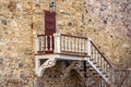 The wall of an old brick building with a door and a beautiful wooden staircase Royalty Free Stock Photo