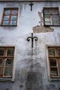 Wall of an old building with cracked stucco, forged decorative patterns and wooden windows.