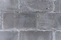 The wall of the old city, built of concrete, gray, porous, shabby blocks texture fragment