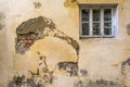 The wall of an old house with a window. The wall needs repair, Collapsed plaster and brickwork. Royalty Free Stock Photo