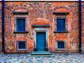 wall of the old red brick with dark door and symmetrical windows Royalty Free Stock Photo