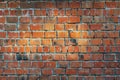 A wall of old red brick with sunlight on it. Brick background of cracked broken bricks Royalty Free Stock Photo