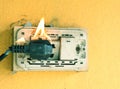 A wall outlet is on fire, with flames and small smoke Royalty Free Stock Photo