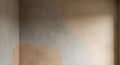 Wall with patches of different colored plaster in beige, light brown, and grey creating a mottled abstract effect Royalty Free Stock Photo
