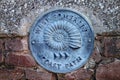 A wall plaque marking the West Somerset Coast Path attached to a building in Minehead