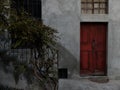 Wall of a private house with a wooden red door and a staircase Royalty Free Stock Photo