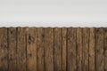 Wall of rough boards with knots from the snow-covered roof