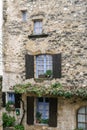 The wall of rough stone with windows of different sizes.