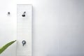 Wall shower on white wall background before swimming in swimming pool.