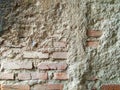 This wall shows a rough texture and some parts of the bricks are visible protruding from the cement layer. Royalty Free Stock Photo