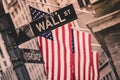 Wall street sign in New York with American flags and New York Stock Exchange in background Royalty Free Stock Photo