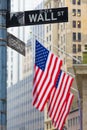 Wall street sign in New York with American flags and New York Stock Exchange in background Royalty Free Stock Photo