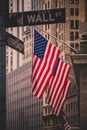 Wall street sign in New York with American flags and New York Stock Exchange in background Royalty Free Stock Photo