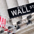 Wall street sign with the New York Stock Exchange on the backgro Royalty Free Stock Photo