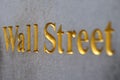 Wall Street word written golden letters on a stone wall