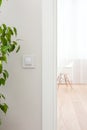 Wall switch in white, modern interior. Open the door to the room