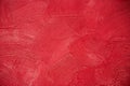 Wall texture with a deep circular dabs of putty, covered with red paint.