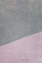 Wall with a texture of plaster, painted in two colors. Pink and gray color on the dioganal. Beautiful background.