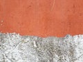 wall texture with a section painted orange and another rustic white with details of the passage of time