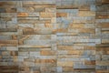 Wall tiles patterned like natural split stone background. Simulated yellow natural stone facade, wall tiles texture.