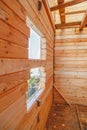 Wall from timber with window of unfinished construction of wooden house Royalty Free Stock Photo