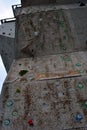 Wall for training rock climbing, close up detail, vertical detail, gray cloudy sky background Royalty Free Stock Photo