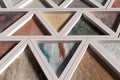 Wall with triangles of different materials in white frames Royalty Free Stock Photo