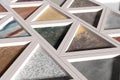 Wall with triangles of different materials in white frames Royalty Free Stock Photo