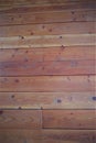 Wall of Vertical Knotty Pine In Reddish Hue